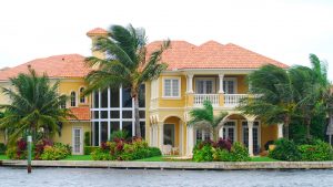 A luxury Florida home on the water with palm trees in its front yard